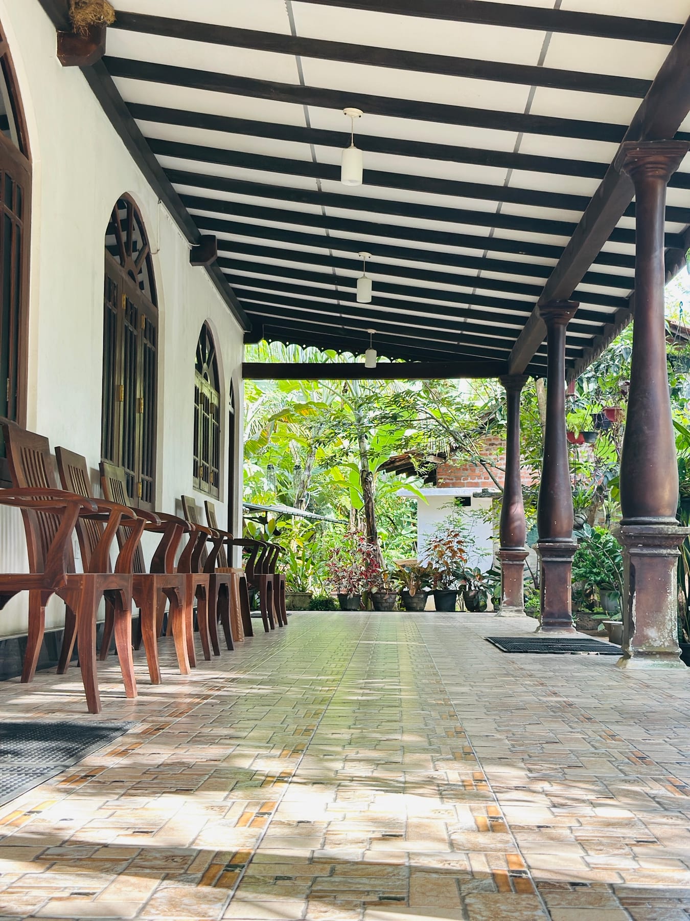 Long covered veranda with timber chairs beside the garden